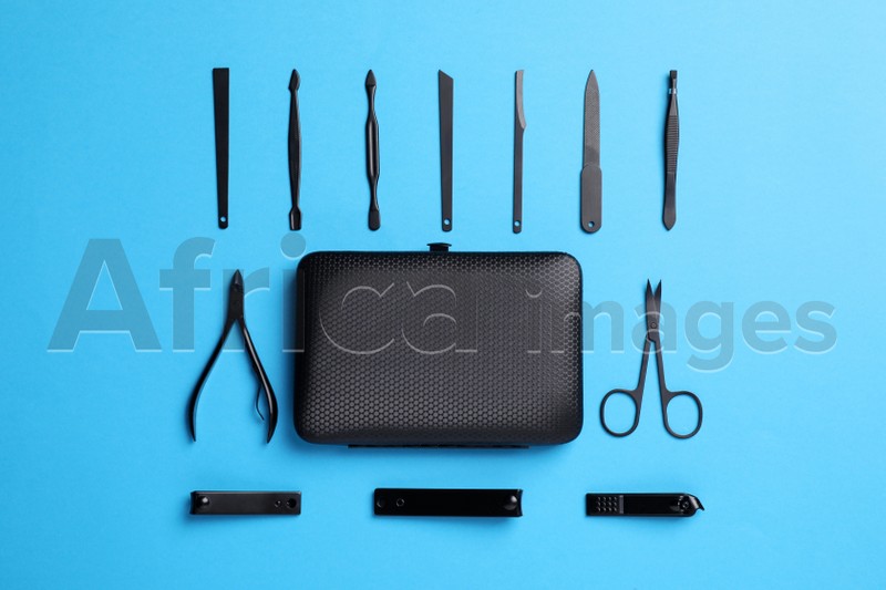 Manicure tools and case on light blue background, flat lay
