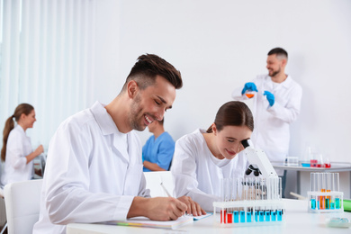 Medical students with microscope in modern laboratory