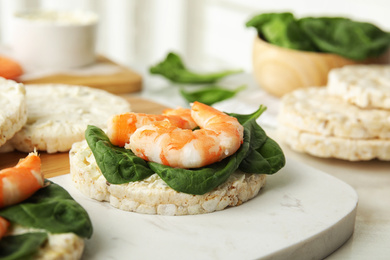 Puffed rice cakes with shrimps and basil on board, closeup