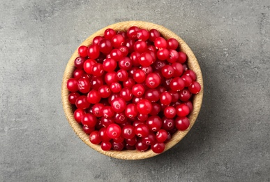 Tasty ripe cranberries on grey table, top view