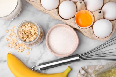 Photo of Different ingredients for cooking tasty oatmeal pancakes on white marble table, flat lay