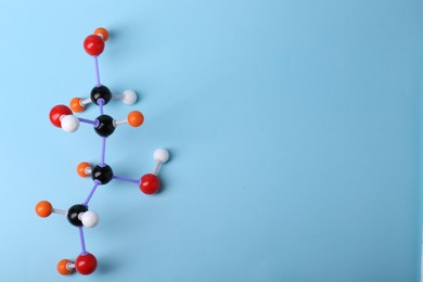 Photo of Molecule of sugar on light blue background, top view and space for text. Chemical model