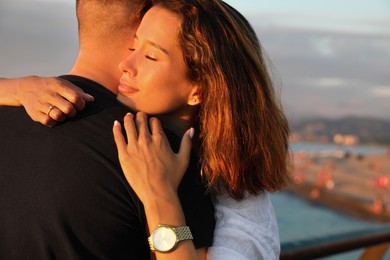Happy young couple hugging on sea embankment
