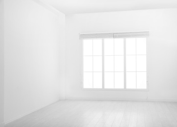 Window with open blinds in empty room