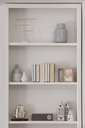 Photo of Stylish shelves with different decor elements in room. Interior design