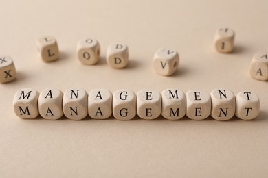 Photo of Word Management made of wooden cubes on beige background