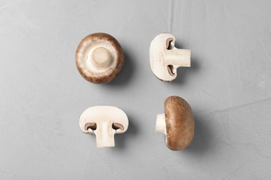 Flat lay composition of fresh champignon mushrooms on grey background