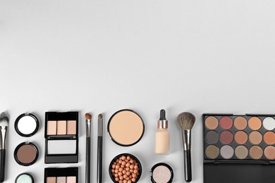 Flat lay composition with makeup brushes on light background, space for text