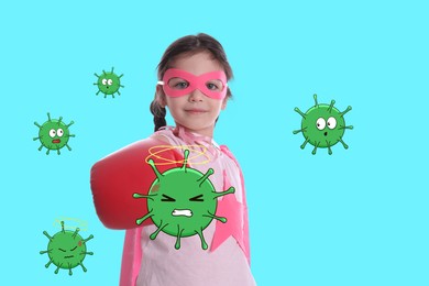 Cute little girl wearing superhero costume and boxing gloves fighting against viruses on turquoise background