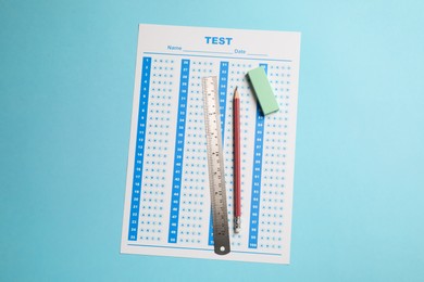 Photo of Answer sheet, pencil and ruler on light blue background, top view. Student passing exam