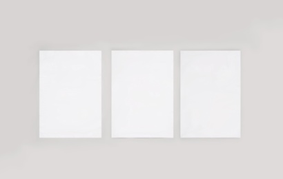 Blank posters on light wall. Mockup for design 