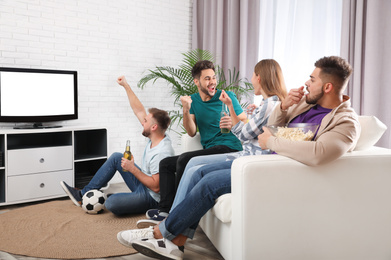 Photo of Group of friends watching football at home