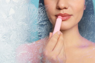 Image of Winter skin care. Closeup of woman applying lip balm, frost effect. Space for text
