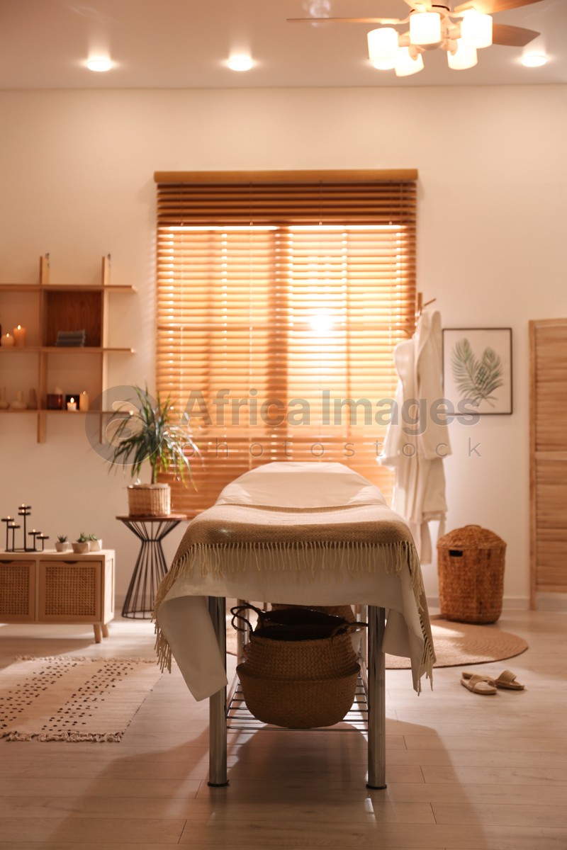 Photo of Stylish massage room interior in spa salon