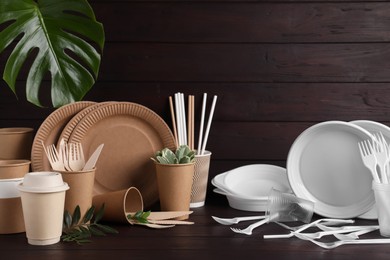 Photo of Plastic and eco disposable tableware on wooden table