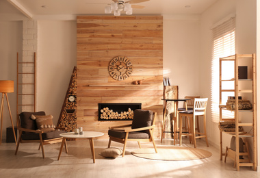 Photo of Decorative fireplace with stacked wood in cozy living room interior