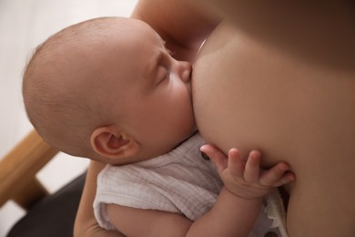 Photo of Woman breastfeeding her cute little baby, closeup