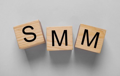Cubes with abbreviation SMM (Social media marketing) on light grey background