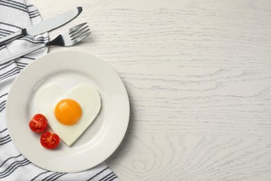 Photo of Heart shaped fried egg served on white wooden table, flat lay. Space for text