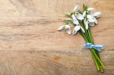 Beautiful snowdrops on wooden table, top view. Space for text