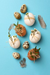 Photo of Festively decorated eggs on light blue background, flat lay. Happy Easter