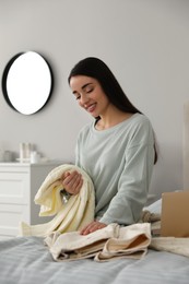 Young woman choosing clothes for work day at home. Morning routine