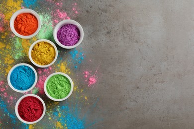 Colorful powder dyes on grey background, flat lay with space for text. Holi festival