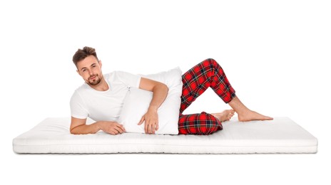Photo of Man with pillow lying on soft mattress against white background