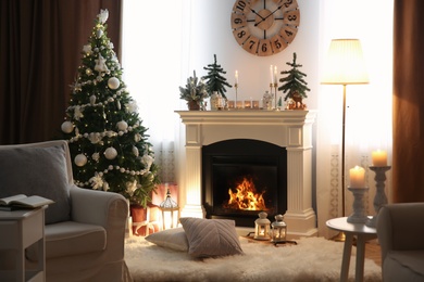 Beautiful room interior with small firs, fireplace and decorated Christmas tree