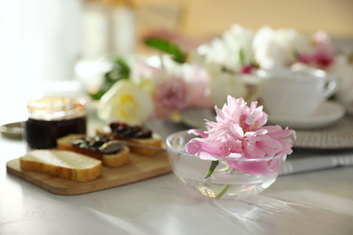 Beautiful pink peony in glass bowl on kitchen counter 
