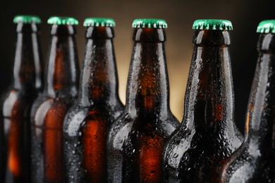 Photo of Many bottles of beer on dark background, closeup