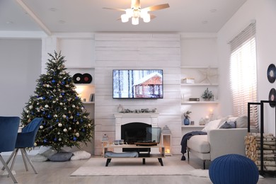 Photo of Stylish living room interior with modern TV, fireplace and Christmas tree