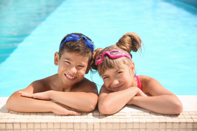 Happy children with goggles in swimming pool