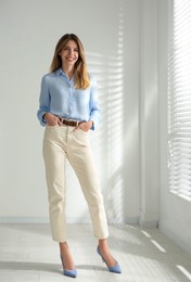 Full length portrait of beautiful young businesswoman in office
