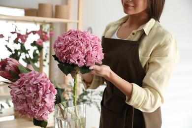 Photo of Florist with beautiful flowers in workshop, closeup