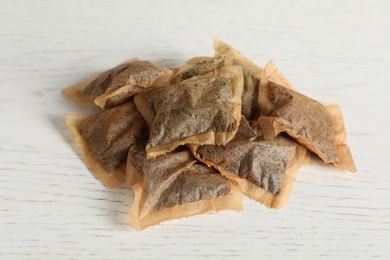 Heap of used tea bags on white wooden table