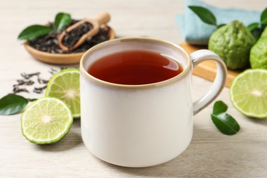 Cup of tasty bergamot tea on white wooden table