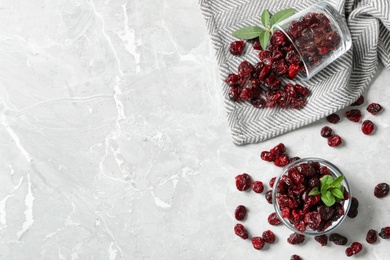 Photo of Flat lay composition with tasty dried cranberries and leaves on grey table. Space for text