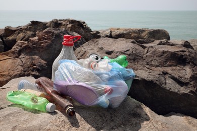 Garbage on stones near sea. Environmental Pollution concept
