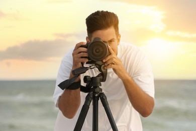 Photographer working with professional camera near sea