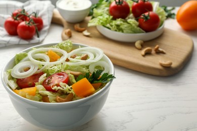 Photo of Bowl of delicious salad with Chinese cabbage, tomatoes and onion on white wooden table, closeup. Space for text