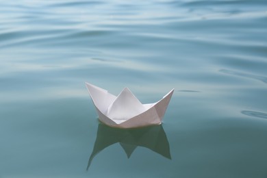 White paper boat floating on water surface