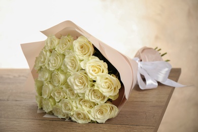 Luxury bouquet of fresh roses on wooden table