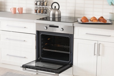 Photo of Open empty electric oven in modern kitchen