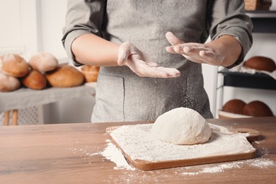 Photo of Man preparing dough at table in kitchen, closeup