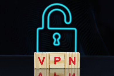 Photo of Acronym VPN (Virtual Private Network) made of wooden cubes on dark background with lock