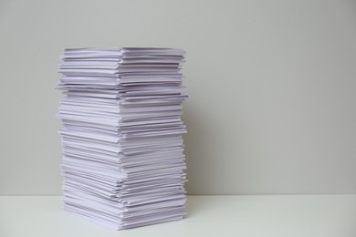 Photo of Stack of paper sheets on white table. Space for text