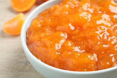 Photo of Delicious tangerine jam in bowl on table, closeup