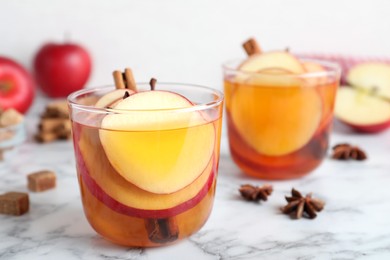 Aromatic hot mulled cider on white marble table
