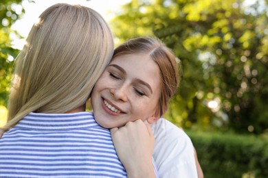 Photo of Happy daughter with her mother spending time together in park on sunny day